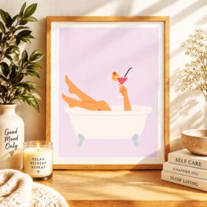Retro Clawfoot Bathtub Wall Art Print displayed in a cozy modern bathroom with framed pastel artwork, plants, candles, towels, and relaxing spa-inspired decor